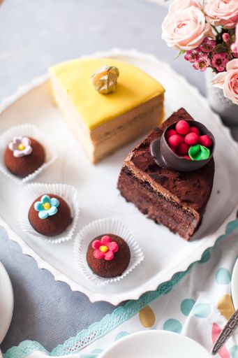 A closeup of tasty sweets on the table served with tea and arranged with flowers