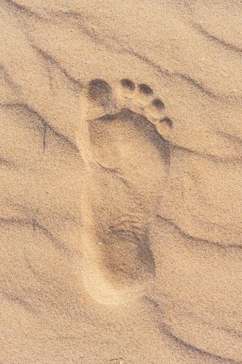 A beautiful beach in Valdelagrana, Cadiz, Spain with orange-hued sand and footprints in the sand