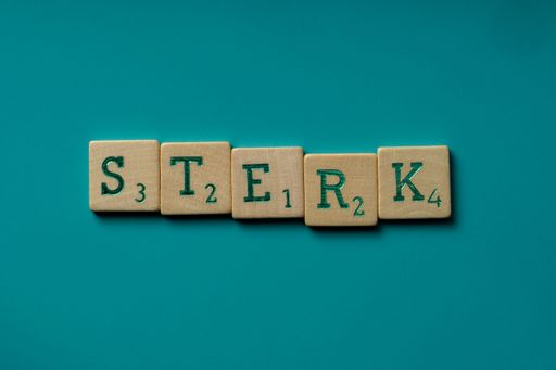 The wooden letters spelling the word "sterk" (dutch for strong) on a blue background.