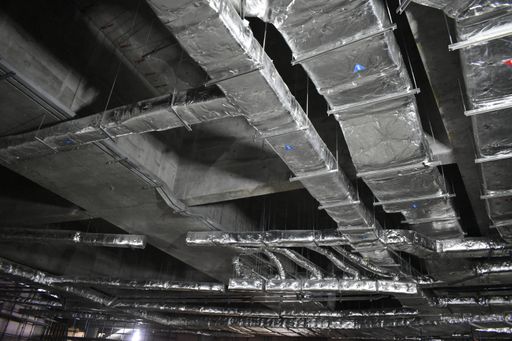 A closeup of aluminum air ducts and piping system of a building