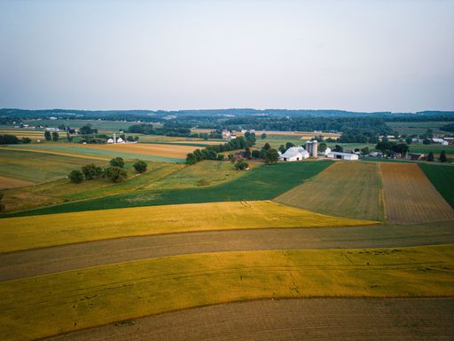 A scenic rural landscape seen from an aerial view featuring lush greenery and rolling hills