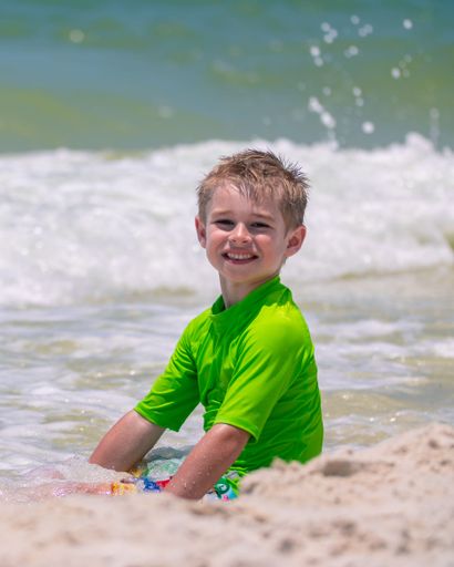 A cheerful young boy enjoying a sunny day at the beach