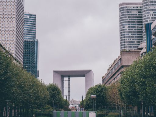 A beautiful shot of the Grande Arche from a park on an overcast day in Paris, France