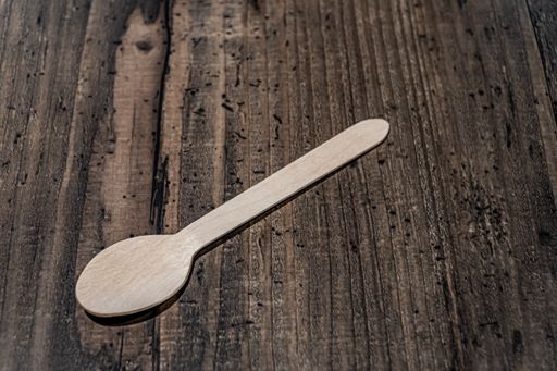 A high angle shot of a wooden spoon on a table