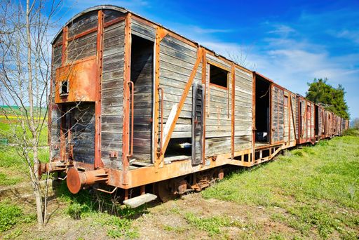 Old train, old wagon, rusty wagon wheels, in an abandoned station. A train that circulated in rails of smaller dimensions.