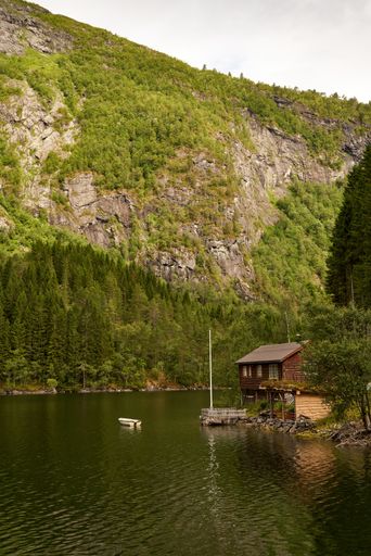 A beautiful mountainous landscape with greenery, lake and cabins in Western Norway