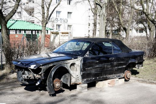 Damages car without wheels at a parking lot