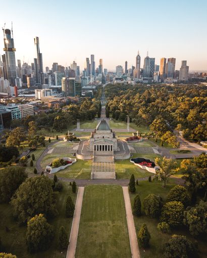 A drone vertical shot of the Shrine of Remembrance in Melbourne with the city skyline in the background