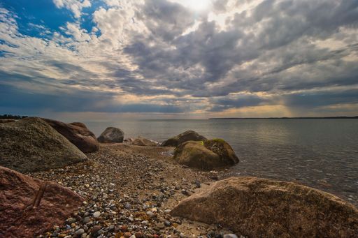 A beautiful sunny day with the sun's rays shining through the clouds and illuminating the rocky terrain below
