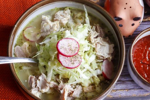 A closeup shot of delicious traditional Mexican white pozole bowl  with lime and radish