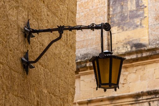A closeup of a street lamp on a building in Mdina, Malta