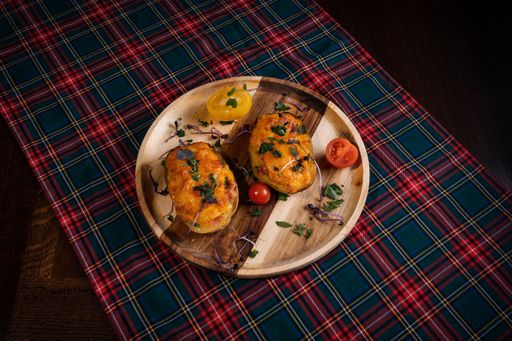 A top-view of delicious stuffed potatoes with cheese and bacon on a wooden serving board