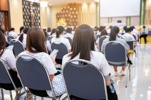 The rear view of college students listening to the lecture in the hall
