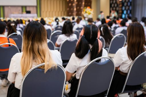 The rear view of college students listening to the lecture in the hall