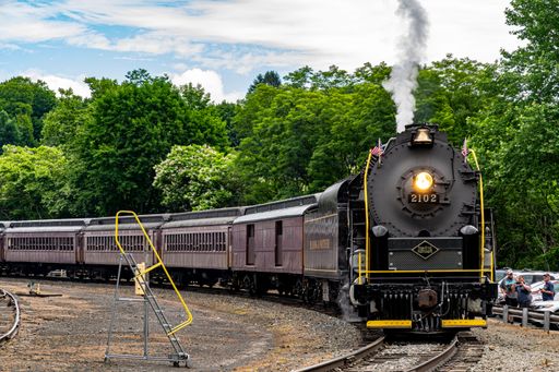 Jim Thorpe, Pennsylvania, July 2, 2022 - A View of A Restored Steam Passenger Train Approaching Around a Curve Traveling Thru Rural America