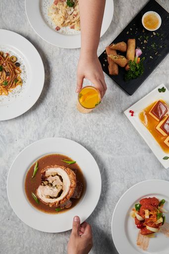A vertical top view of different decorated dishes served on plates on the table
