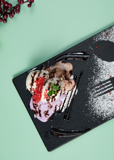 A vertical top view of sweet ice cream served on a black plate