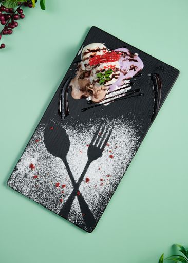 A vertical top view of sweet ice cream served on a black plate
