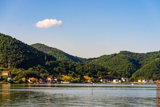 A beautiful view of Danube Gorge (Iron Gates) with buildings and mountain forests under a clear sky