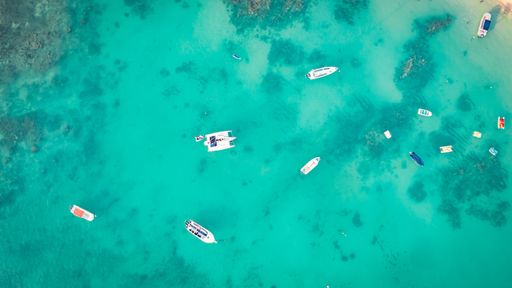 An aerial view of boats moored in the crystal clear turquoise sea. Mauritius, East Africa.