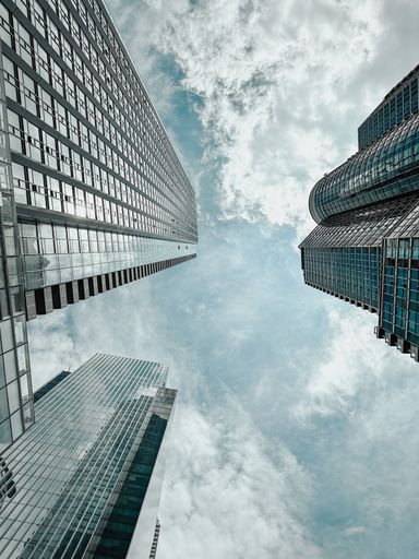 A low angle of skyscrapers against the cloudy blue sky