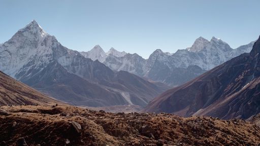 A majestic snowy mountain range with several prominent peaks in the background