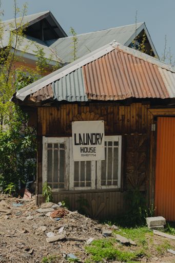 An exterior shot of a wooden building featuring a sign saying 'Laundry House' in the village of Shogran, Pakistan