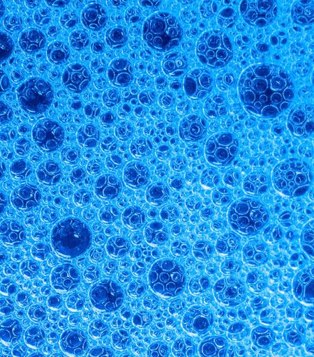 A bright blue background with different sized bubbles