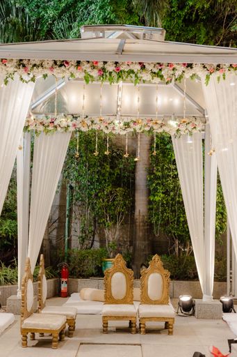 A vibrant outdoor wedding celebration featuring beautiful white chairs
