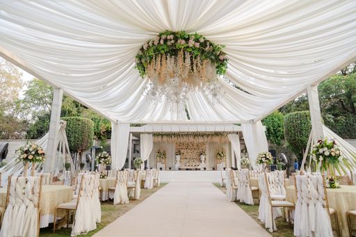 A luxurious white wedding reception featuring elegant floral centerpieces and seating arrangements