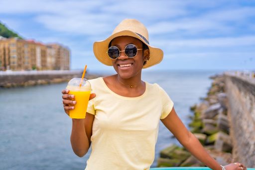 A shallow focus of a young African-American woman drinking smoothie in a park