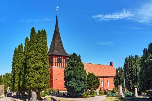 The beautiful view of the trees and a church in Svaneke, Bornholm island, Denmark under the blue sky