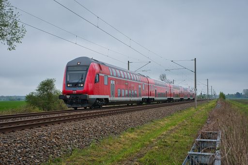 A red train traveling through scenic German landscape.