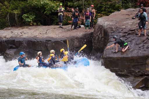 A diverse group of people rafting together in a flowing river