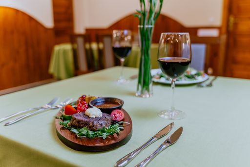 A healthy dinner table for two, with plates of tasty appetizing food and red wine glasses