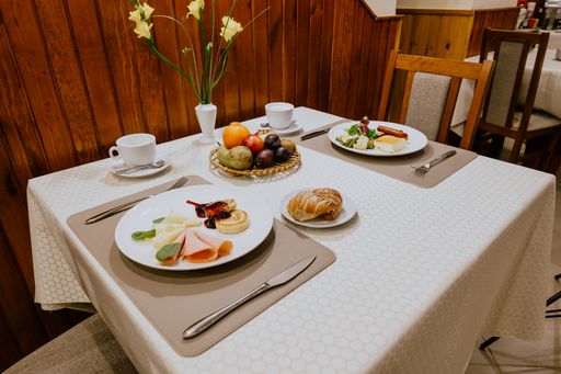 A close-up shot of fresh breakfast with ham and fruits in the cafe