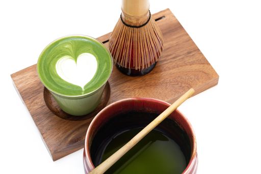 A closeup of a glass of delicious matcha on a tray on the table