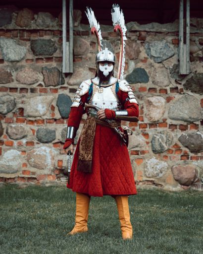A vertical shot of a person in a full warrior costume outdoors