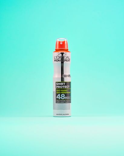 An image of a L'Oreal Men Expert antiperspirant bottle against a vivid and vibrant background