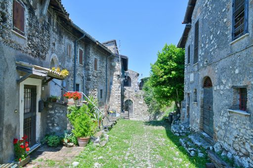A narrow street among the old houses of a medieval town in the Lazio region.