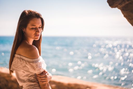 A young attractive woman from Spain dressed in white resting by the sea