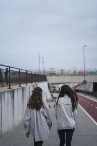 A vertical shot of two white Caucasian women walking together
