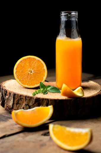 A vertical shot of a bottle of fresh orange juice on the table