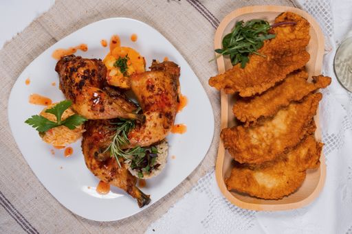 A top view of fried chicken with rice served on a white plate and wooden tray