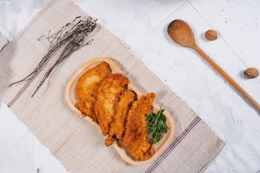 An overhead shot of fried chicken meat served on a wooden tray