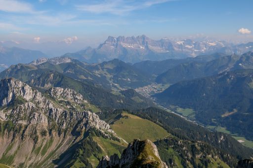 A beautiful landscape of a mountain range with a lush grassy valley at its base