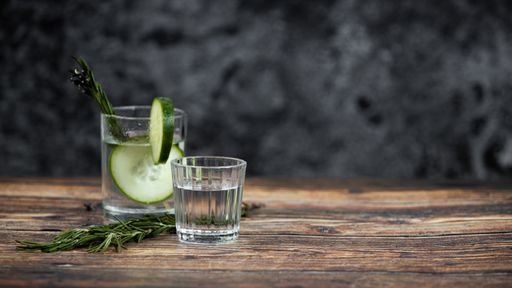 A closeup shot of two tequila shots with cucumber slices