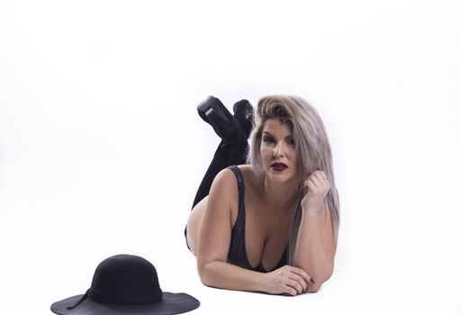 A Hispanic plus-size woman wearing a bikini and lying on the ground isolated on a white background