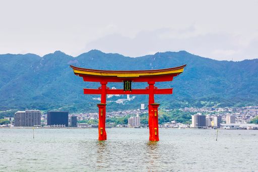 A majestic red Torii gate floating in the water in Miyajima, Hiroshima, Japan.