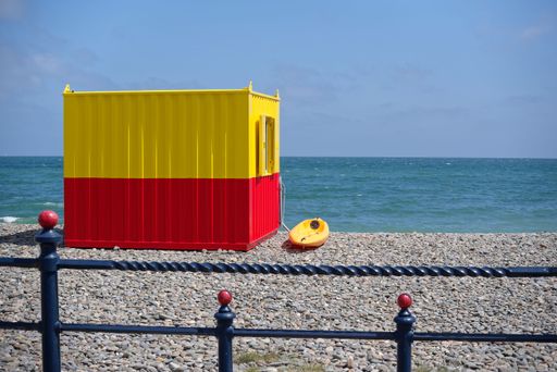 Lifeguard house on public pebble beach in Bray, Ireland. The Irish Sea and blue sky on the horizon. Sunny summer day.